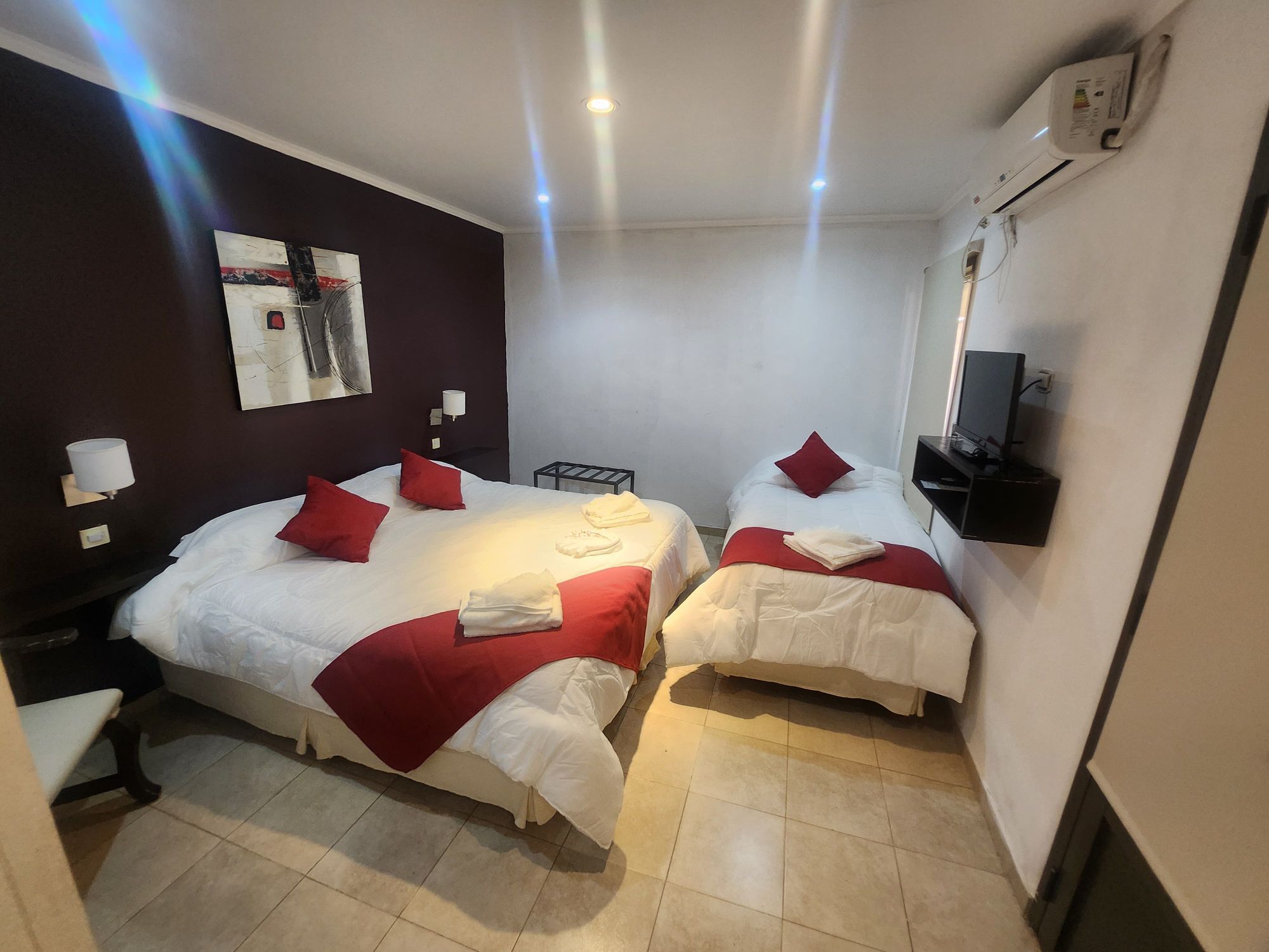 Habitación con camas individuales y pared roja