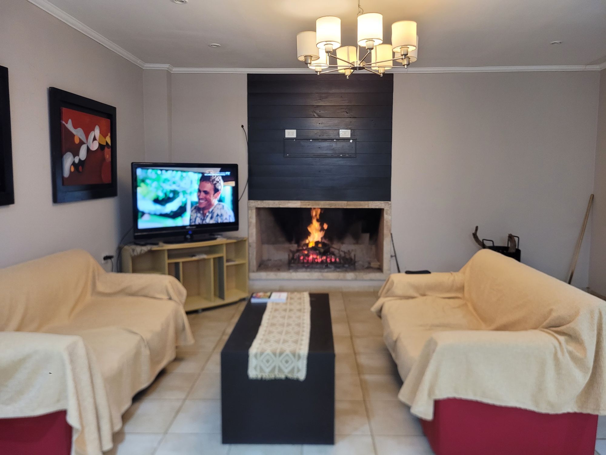 Sala común con hogar a leña y televisor