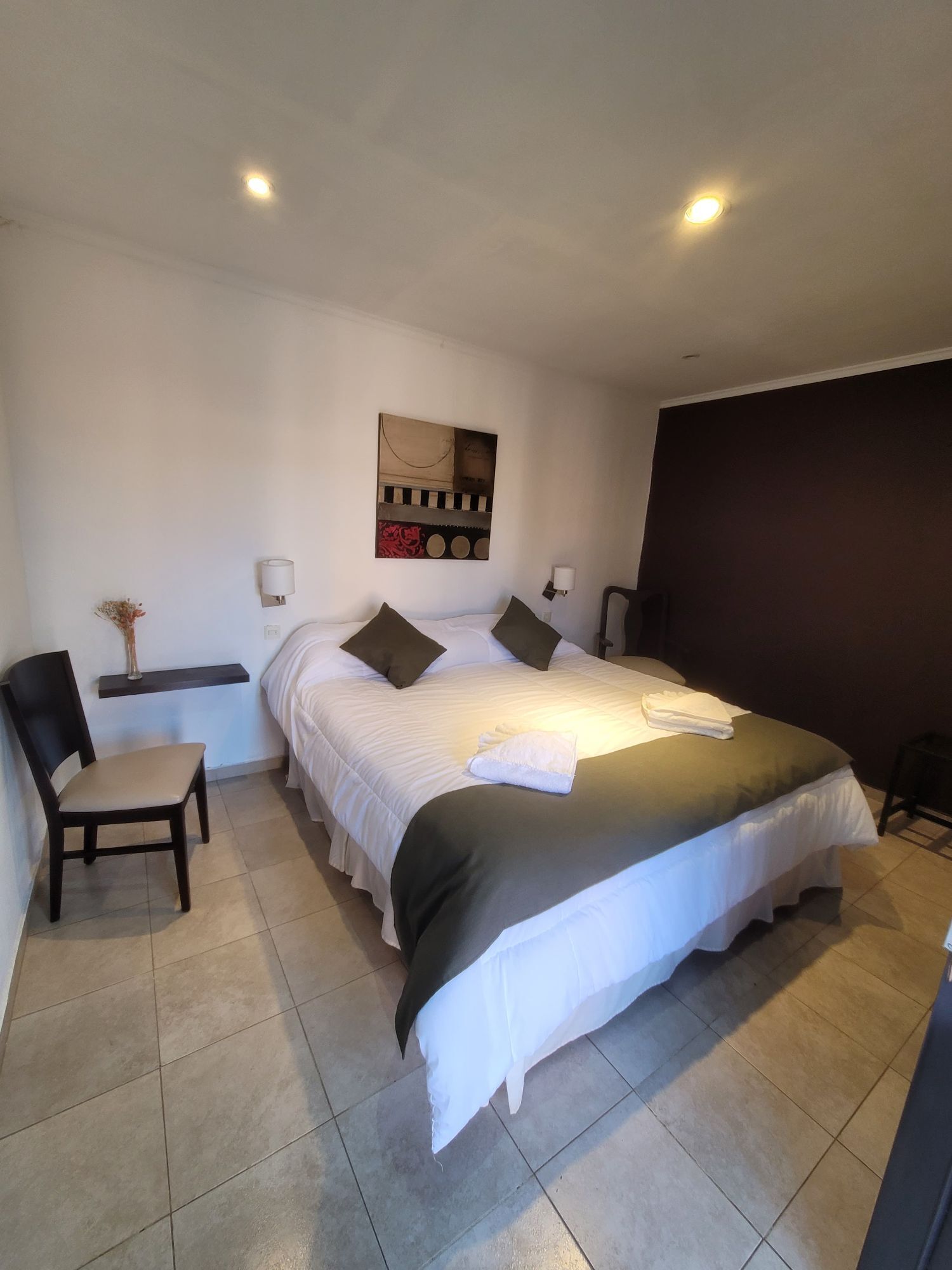 Habitación con cama matrimonial y detalles verdes